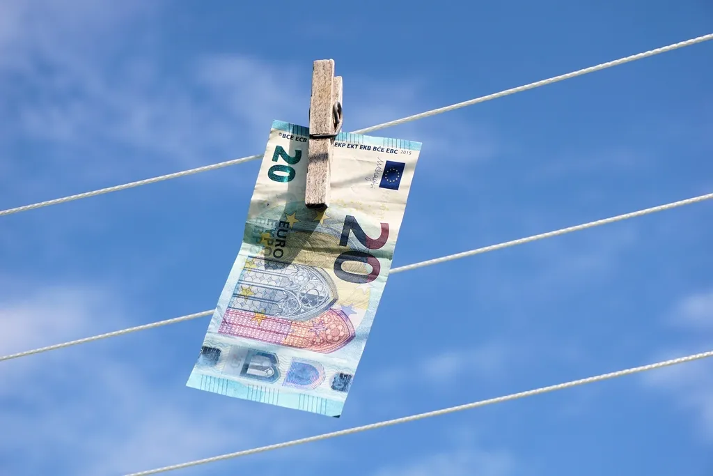 20 euro note hanging from a line by a clothes peg, against a blue sky