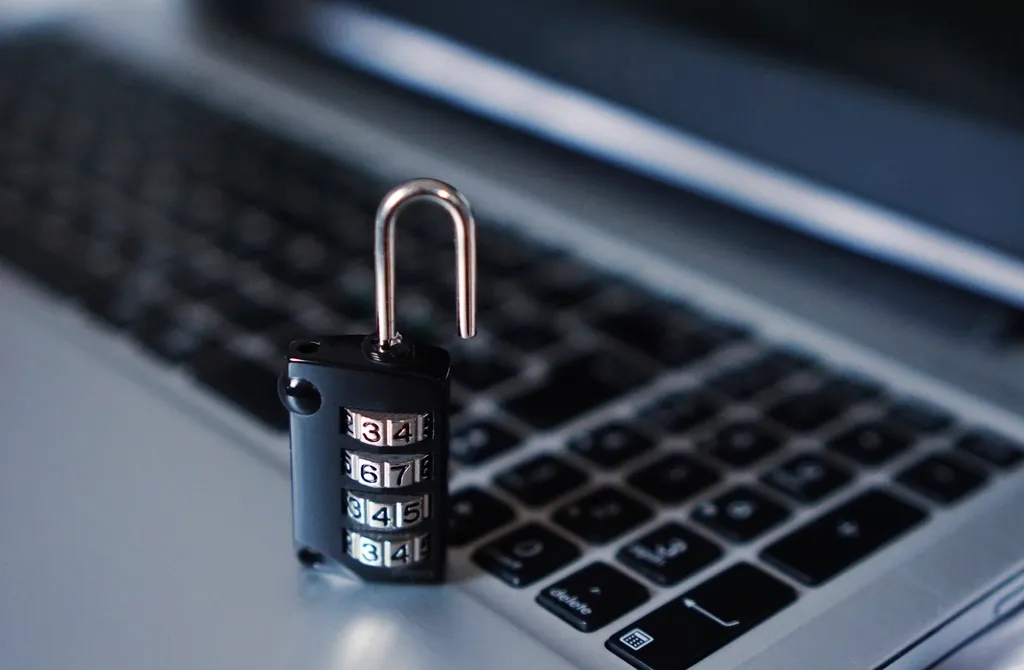 Cadenas à combinaison posé sur le clavier d'un ordinateur portable