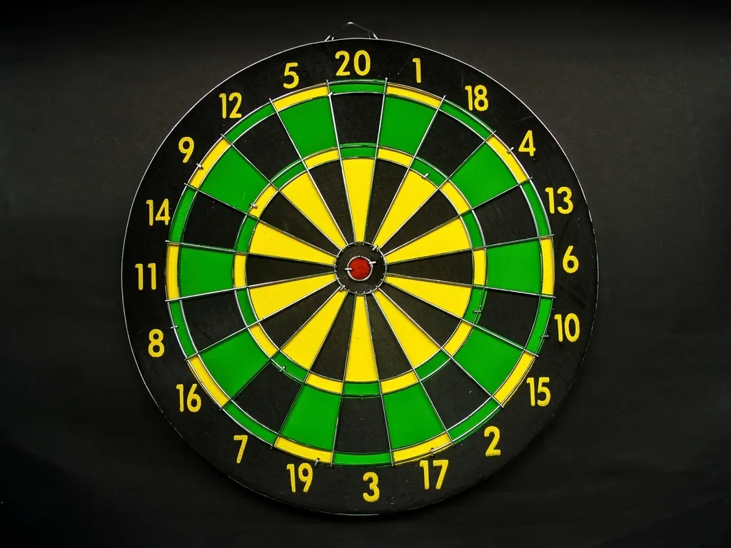 Green and black dartboard with a dart in the centre