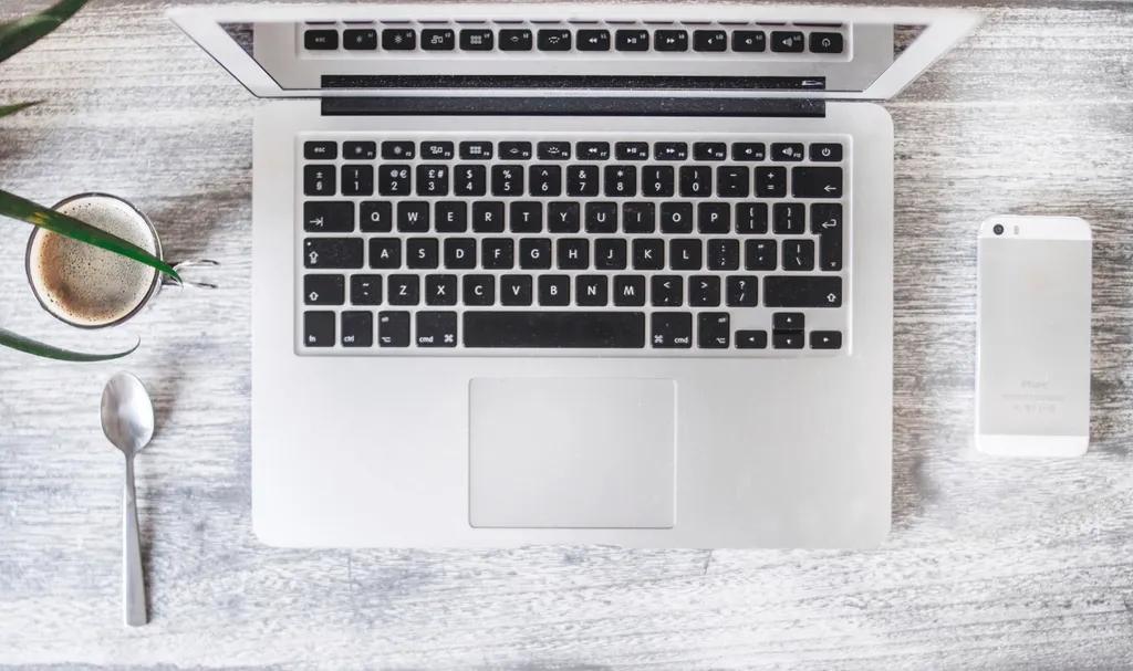 Clavier d'ordinateur portable, téléphone et tasse de café vus de dessus