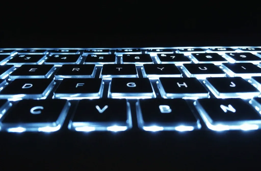 Clavier d'ordinateur rétroéclairé en bleu dans la pénombre