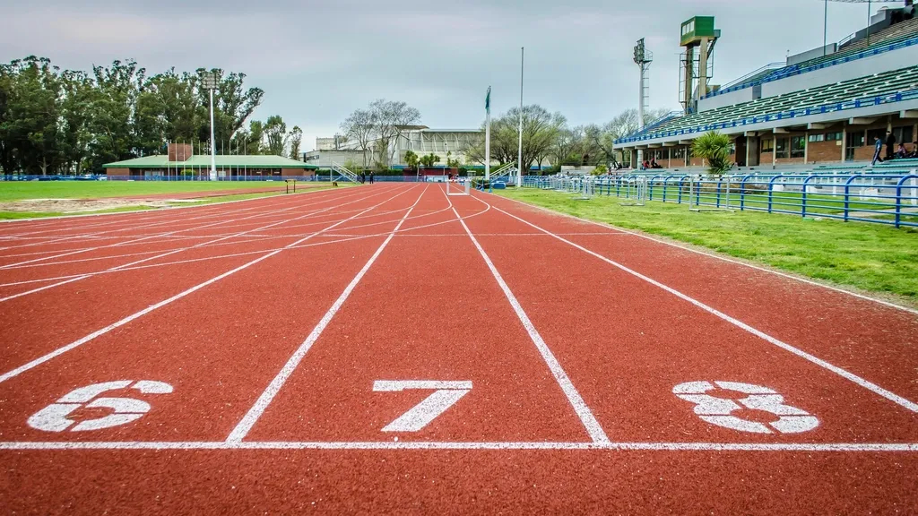 Numbered lanes of a running track in front of stadium stands