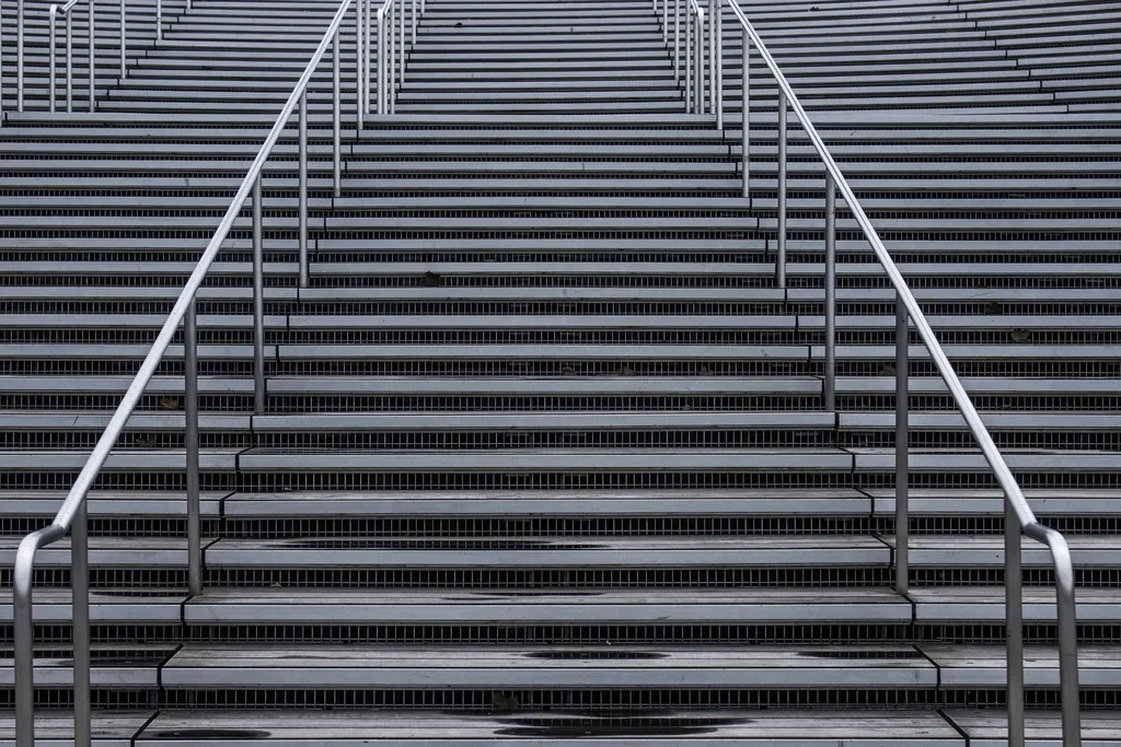 Escalier en béton avec une rampe métallique, vu de face
