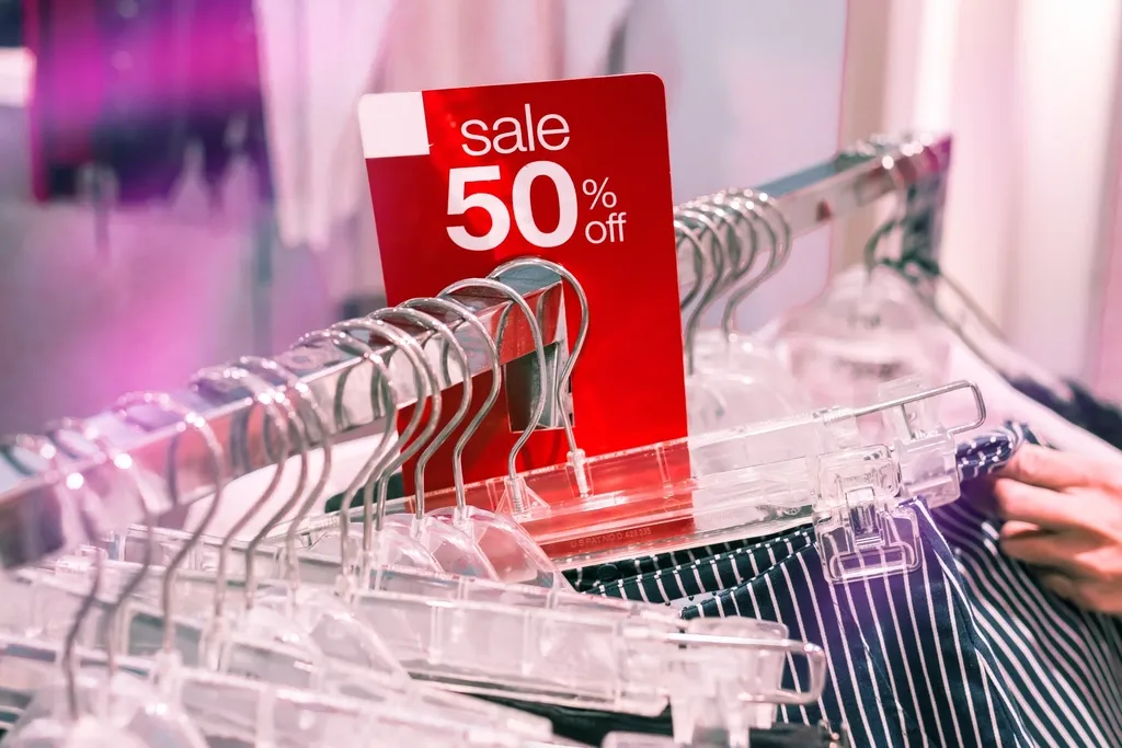 Étiquette « sale 50 % off » accrochée à un portant de cintres