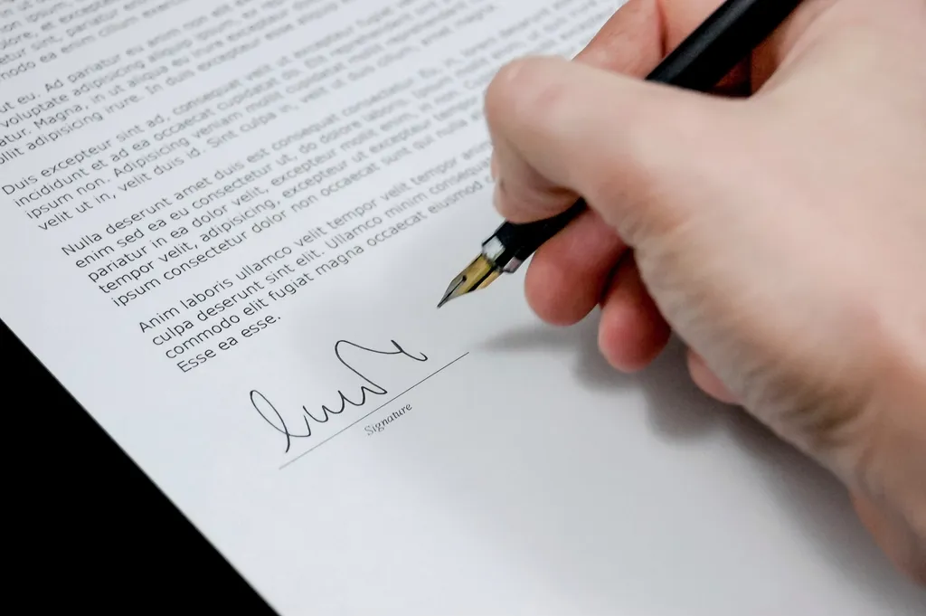 Hand signing a contract with a fountain pen