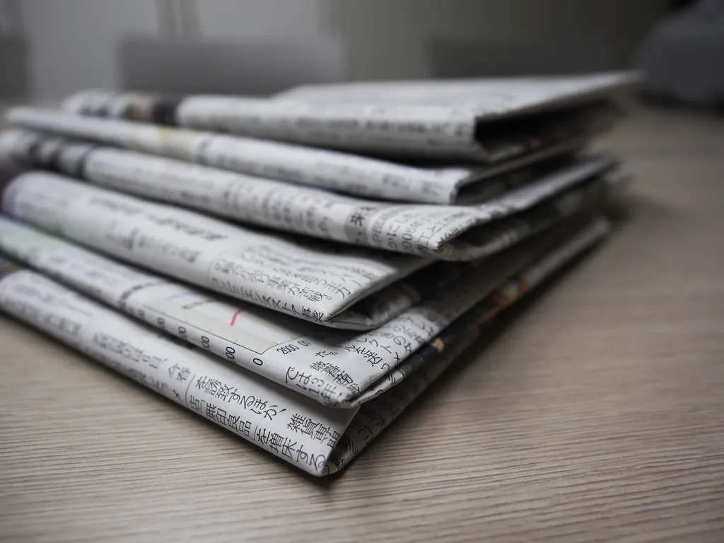 Pile de journaux pliés sur une table sombre