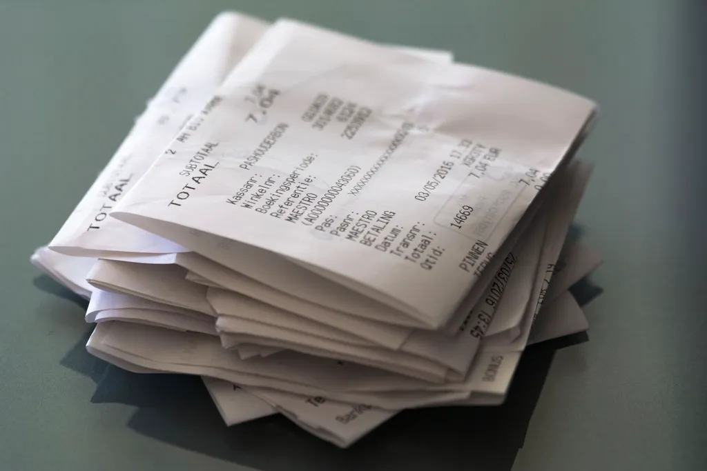 Pile de tickets de caisse froissés sur une table