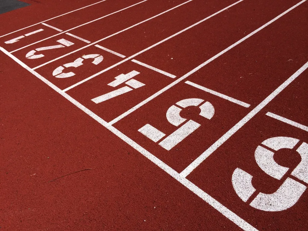 Ligne de départ d'une piste d'athlétisme rouge avec les numéros de couloirs