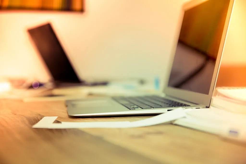 An open laptop on a wooden desk in warm light
