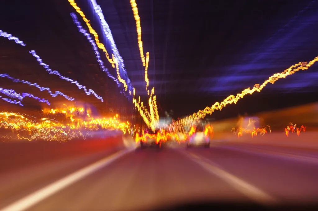 Traînées lumineuses multicolores dans un tunnel, effet de vitesse